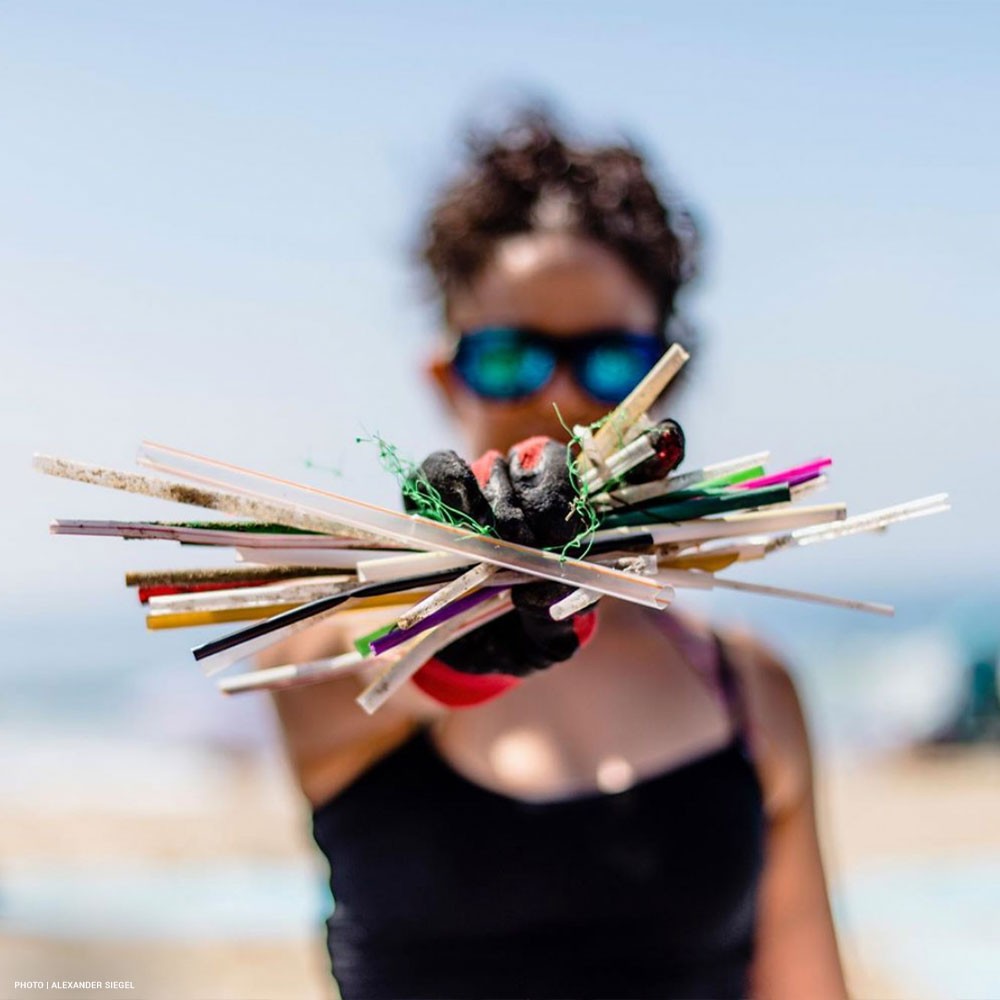 Photo a a Surfrider volunteer holding plastic straws